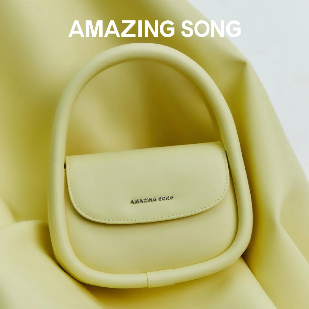 Amazing Song yellow handbag on matching soft fabric, elegant minimalist accessory
