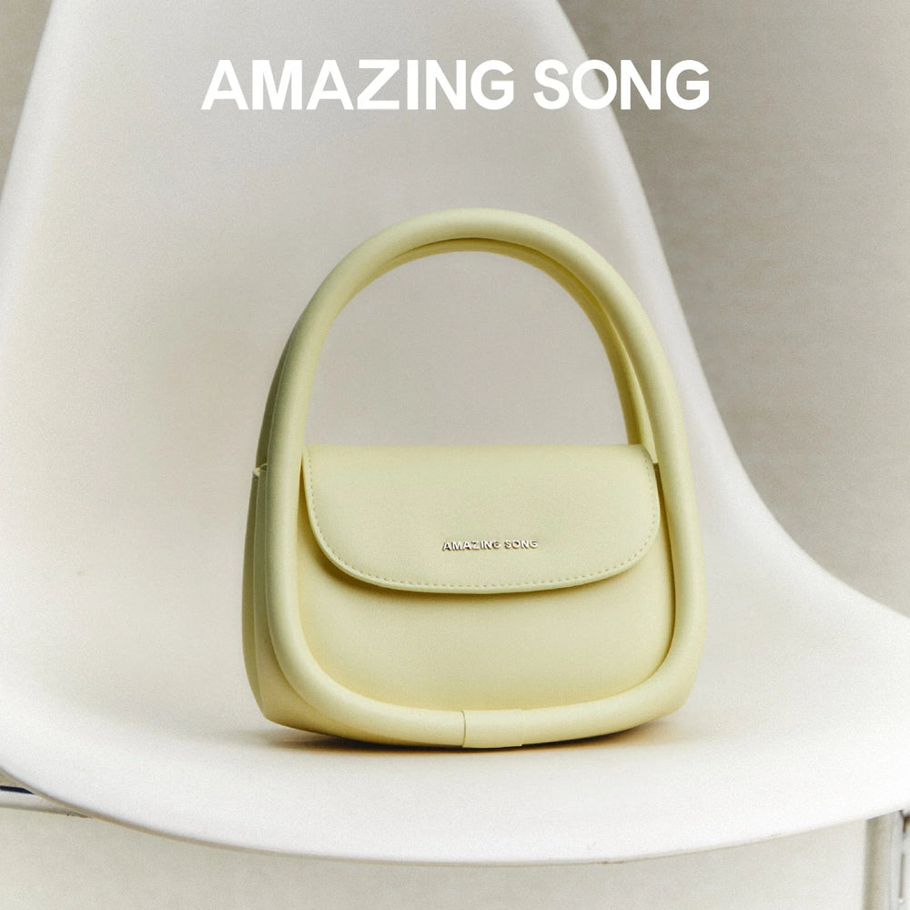 Amazing Song pastel yellow designer handbag displayed on a modern white chair