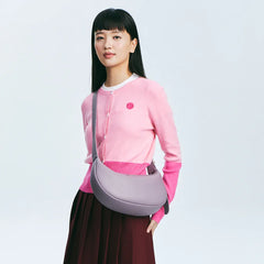 Woman in pink cardigan with purple crossbody bag, Amazing Song official website style