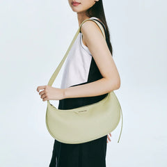 Woman holding light yellow shoulder bag, fashion accessory on Amazing Song official website