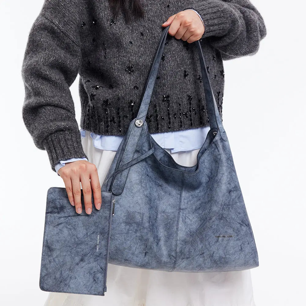 Woman holding a blue Amazing Song tote bag and matching pouch, fashion accessory