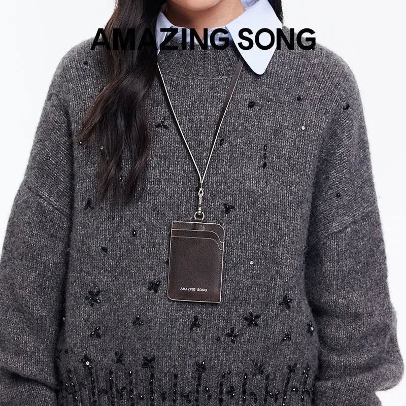 Amazing Song card holder on lanyard, worn over gray beaded sweater, official website promo