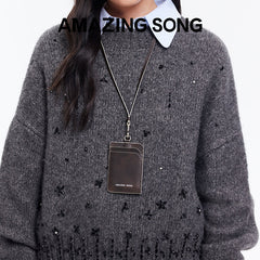 Amazing Song card holder on lanyard, worn over gray beaded sweater, official website promo