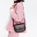 Woman in pink denim jacket with brown leather crossbody bag, Amazing Song accessories