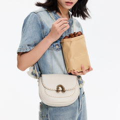 Woman in denim outfit holding white crossbody bag and paper bag of chestnuts, Amazing Song