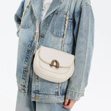 White crossbody handbag with gold clasp on denim jacket, Amazing Song fashion accessory