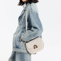 Woman in denim jacket and jeans with a cream leather shoulder bag, Amazing Song style