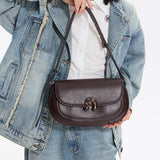 Woman in denim jacket holding stylish dark brown leather shoulder bag, Amazing Song