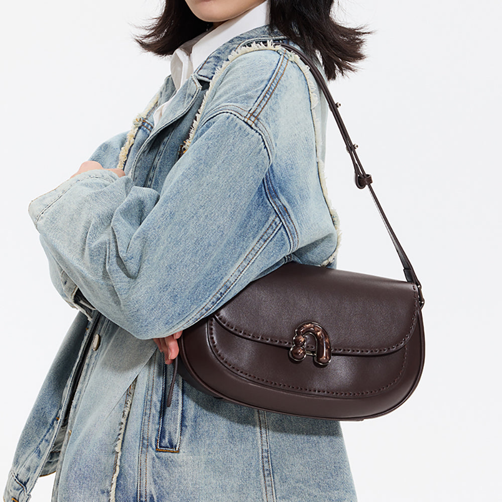 Woman in denim jacket holding a dark brown leather shoulder bag, Amazing Song fashion