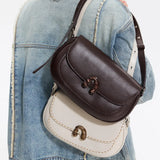 Two leather crossbody handbags, brown and cream, styled on a denim jacket, Amazing Song