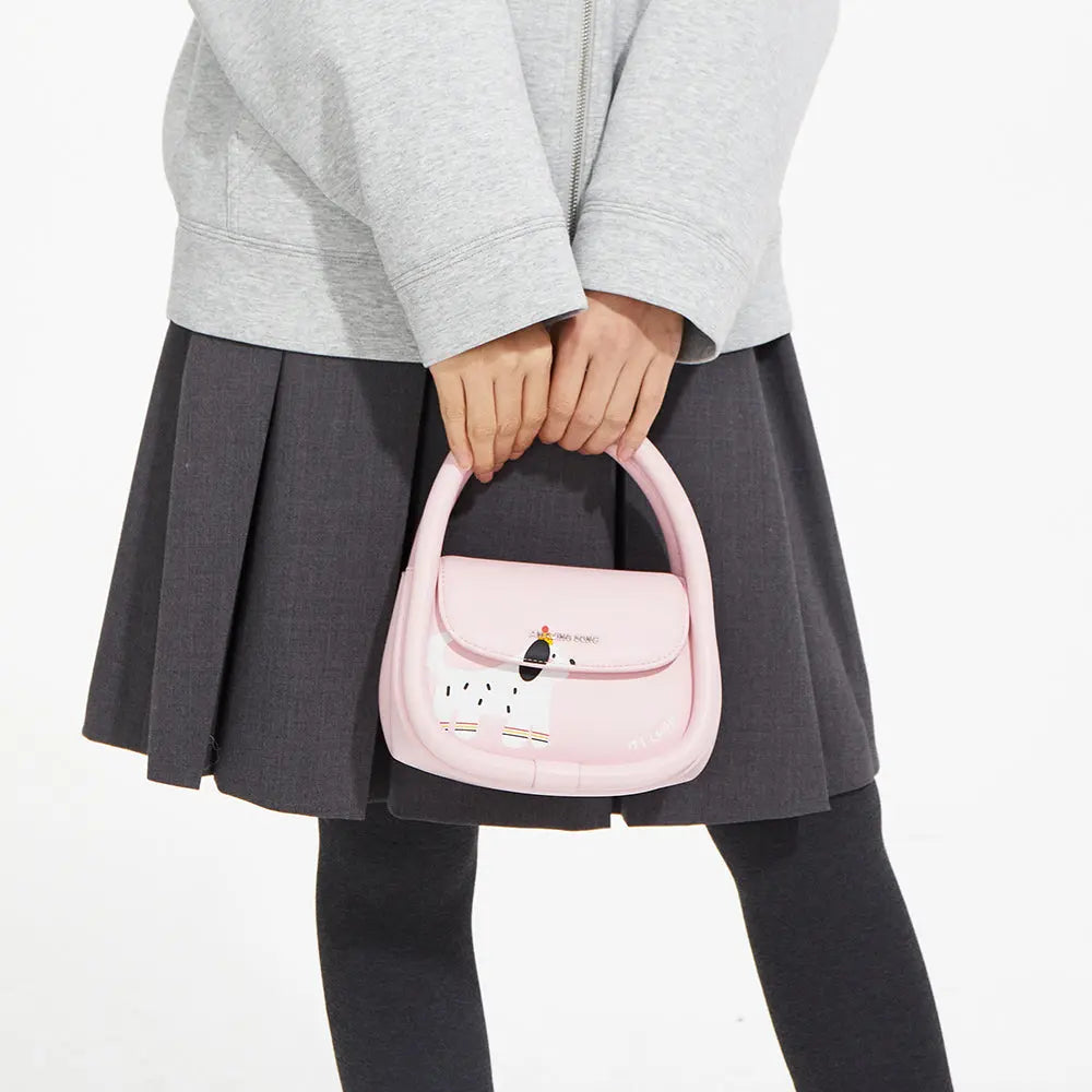 Person in grey jacket and skirt holding a pink handbag with a cute dog design from Amazing Song.