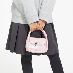 Person in grey jacket and skirt holding a pink handbag with a cute dog design from Amazing Song.