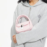Woman in grey hoodie holding pink Amazing Song handbag with dog print