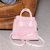 Light pink denim handbag with handles and shoulder strap on gray floor by brown couch, Amazing Song