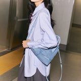 Woman in blue shirt with denim shoulder bag at subway station, Amazing Song fashion style