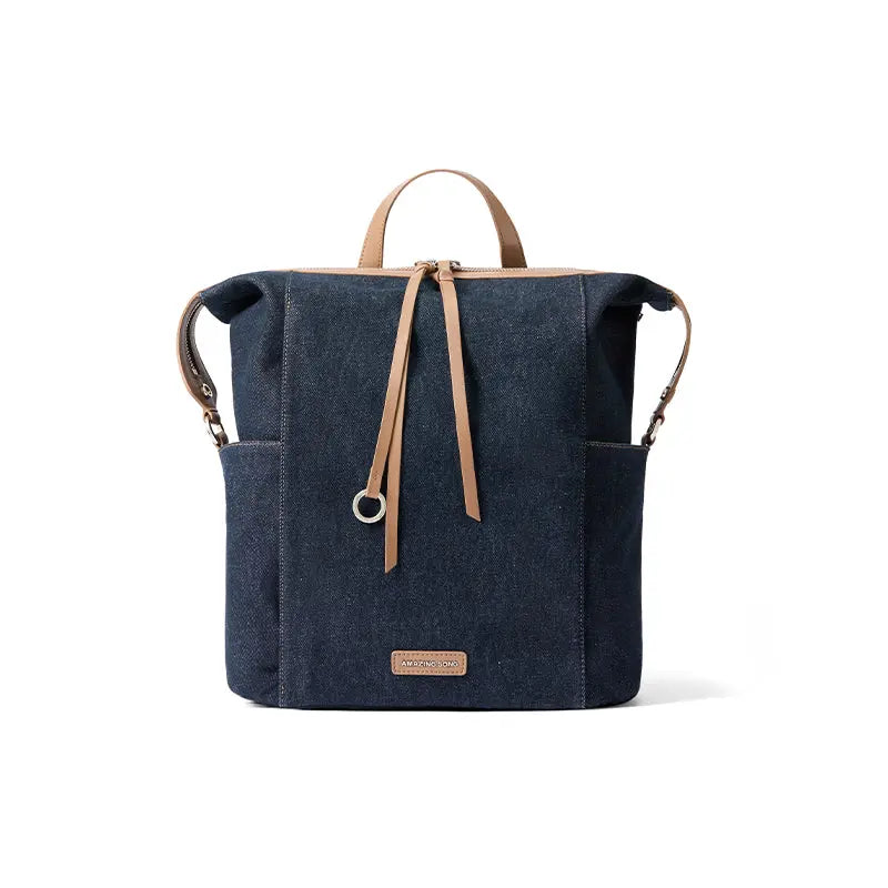 Amazing Song navy denim backpack with tan leather straps on white background