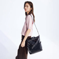 Woman in light pink top carrying large black leather shoulder bag, Amazing Song style