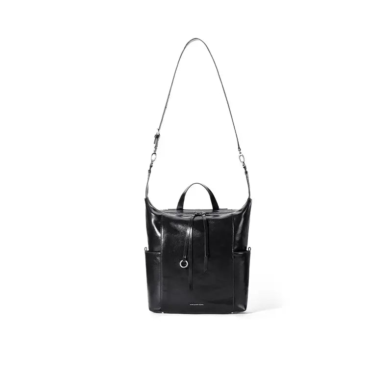 Sleek black leather backpack with long strap, front drawstring, and side pockets on white background