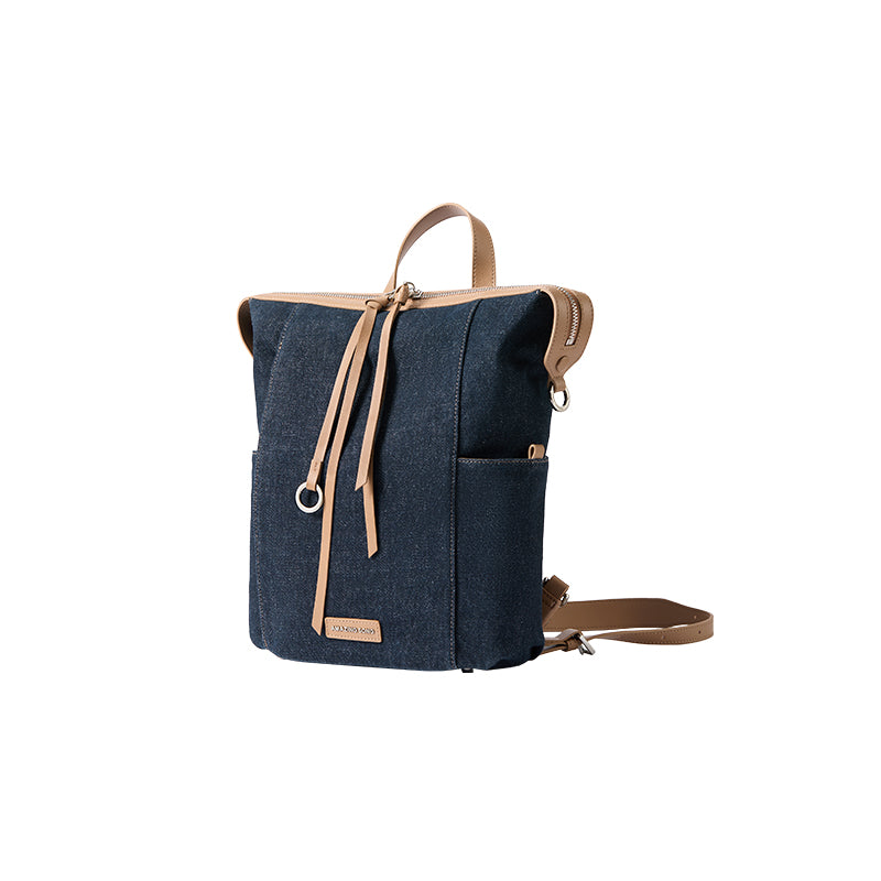 Dark blue canvas backpack with tan leather straps, displayed on white background