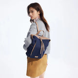 Woman wearing a blue denim backpack, grey sweater, and tan skirt, Amazing Song official website