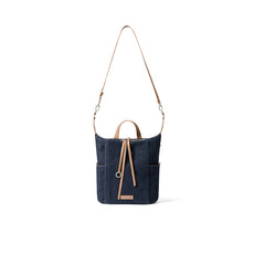 Dark blue denim shoulder bag with tan leather straps on white background, Amazing Song