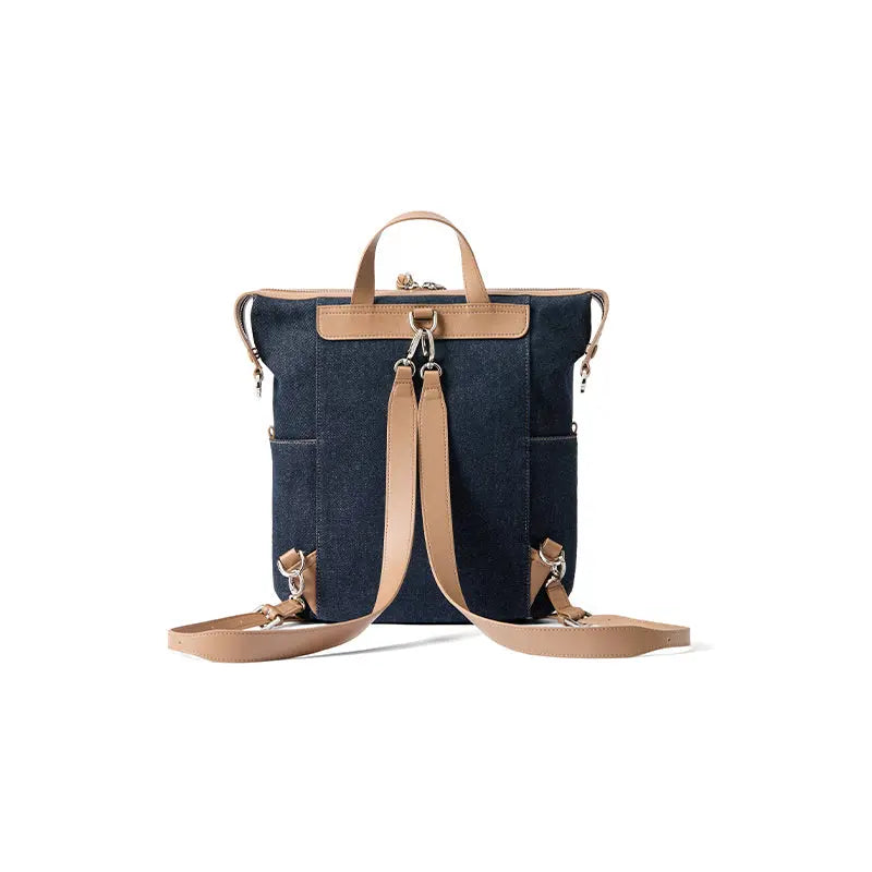 Denim backpack with tan leather straps on white background, Amazing Song official website