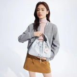 Woman in grey jacket and beige skirt holding a light blue bucket bag, Amazing Song fashion