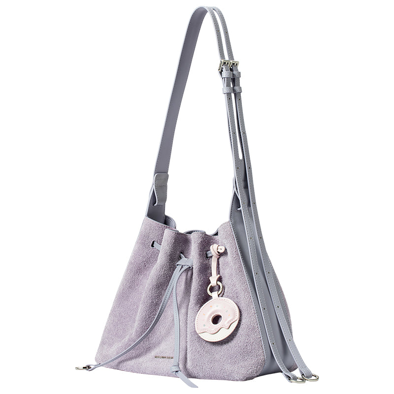 Light purple suede bucket bag with adjustable strap and donut-shaped keychain, Amazing Song