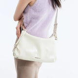 Woman wearing a lilac sleeveless sweater with a cream Amazing Song shoulder bag
