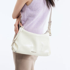 Woman wearing a lilac sleeveless sweater with a cream Amazing Song shoulder bag