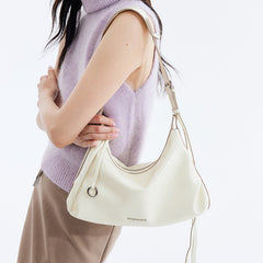 Woman wearing sleeveless lavender sweater with cream Amazing Song shoulder bag