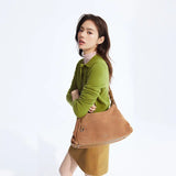 Woman in green sweater with tan handbag, Amazing Song fashion accessory on white background