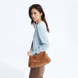 Woman in light blue sweater with brown suede shoulder bag, Amazing Song fashion