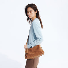 Woman in light blue sweater with brown suede shoulder bag, Amazing Song fashion