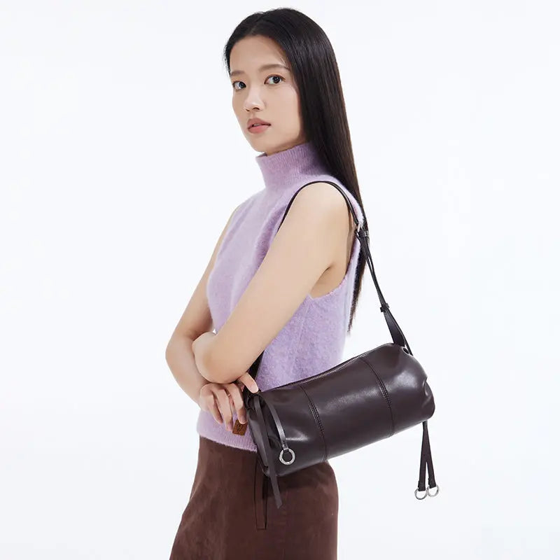 Woman in sleeveless lavender sweater with dark brown leather shoulder bag, Amazing Song
