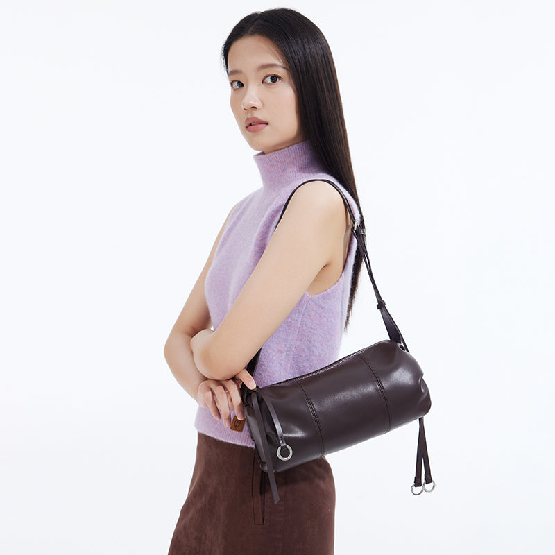 Woman in sleeveless lavender sweater with dark brown leather shoulder bag, Amazing Song