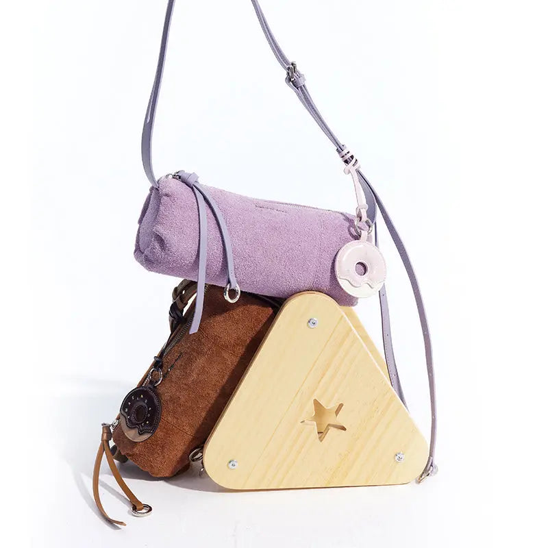 Purple suede purse, brown suede pouch, and wooden star triangle bag with donut charm