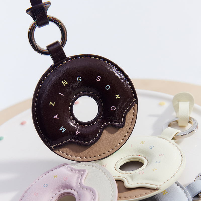 Donut-shaped leather keychain with Amazing Song logo, in brown, white, and pastel colors