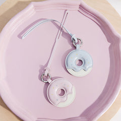 Pastel donut-shaped Amazing Song keychains on a pink tray