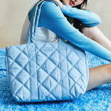 Woman with Amazing Song light blue quilted tote bag on blue textured rug