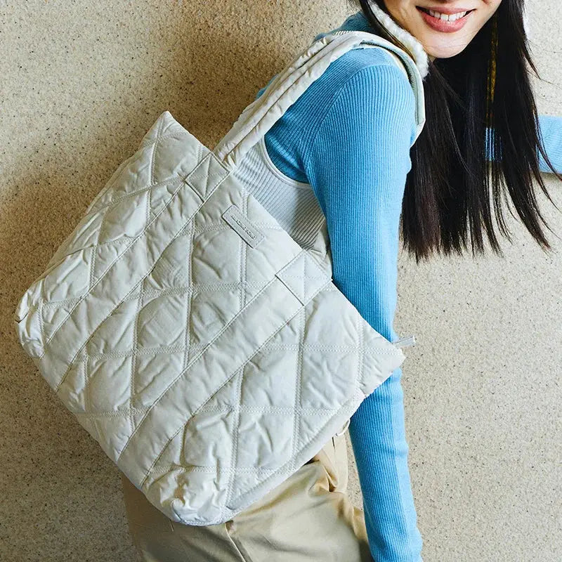 Woman carrying large quilted white tote bag, Amazing Song website style accessory