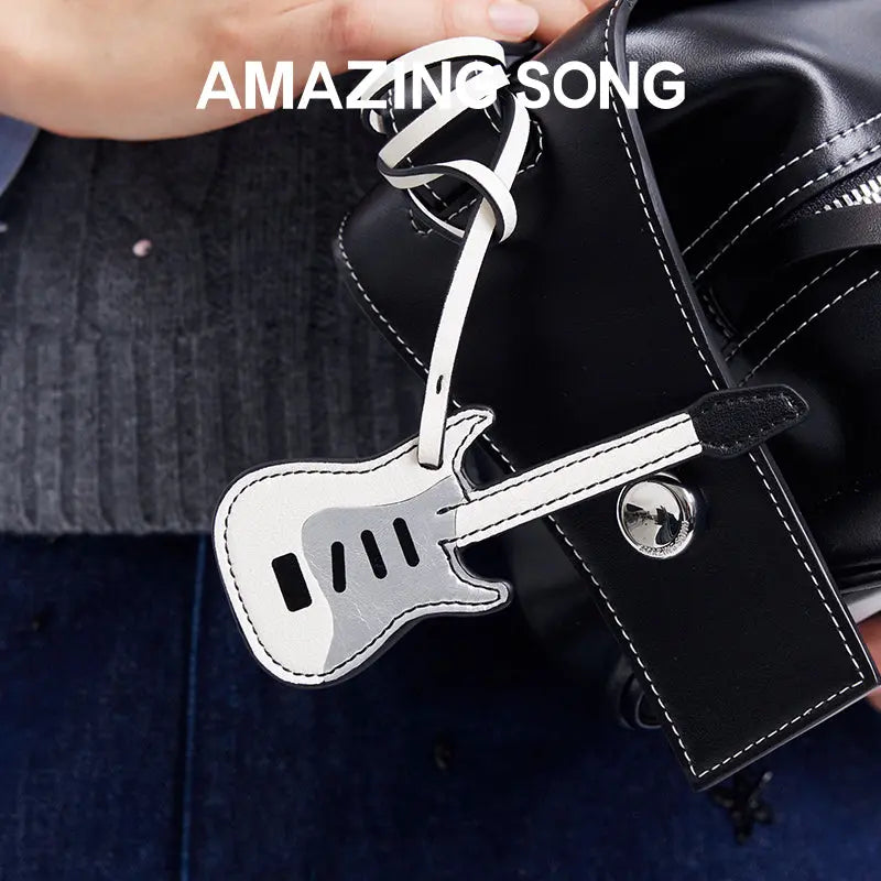 Amazing Song guitar-shaped keychain on black leather bag