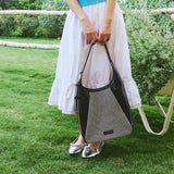 Woman outdoors holding black and white chevron tote bag, white skirt, Amazing Song