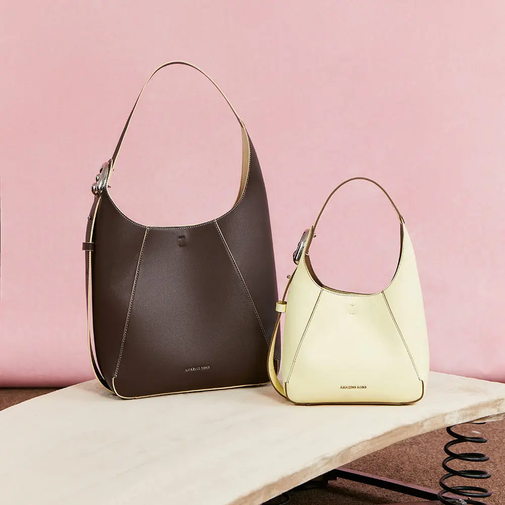 Amazing Song brown and cream leather handbags on display with pink background