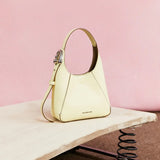 Yellow leather Amazing Song handbag on beige surface with pink background