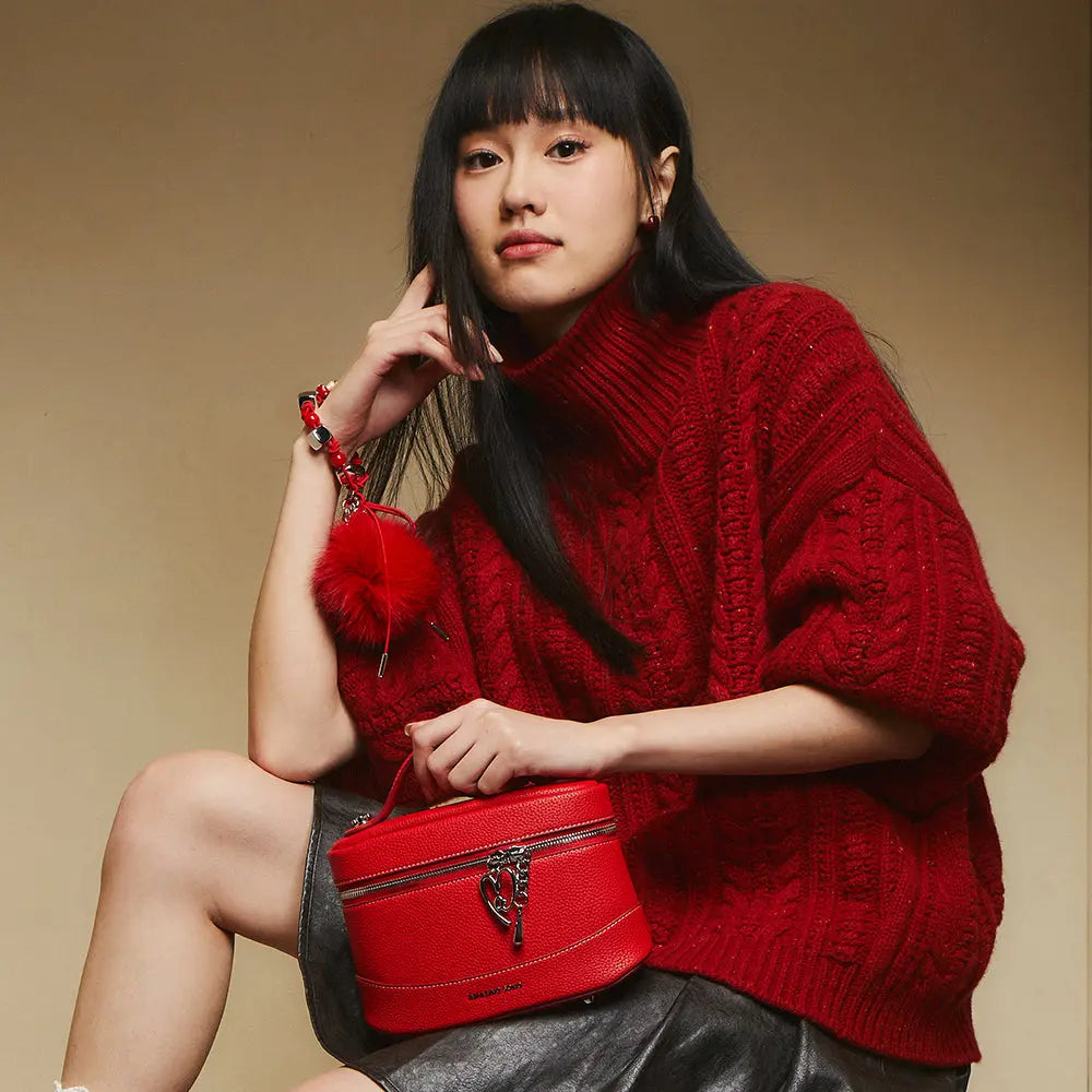Woman in red knit sweater holding red leather handbag, Amazing Song fashion accessory
