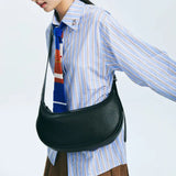 Woman wearing striped shirt, blue tie, and black leather shoulder bag, Amazing Song fashion.