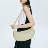 Woman holding light yellow shoulder bag, fashion accessory on Amazing Song official website