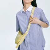 Woman in blue striped shirt wearing yellow crossbody bag, Amazing Song official website