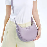 Woman wearing a white shirt, beige pants, and lilac Amazing Song shoulder bag